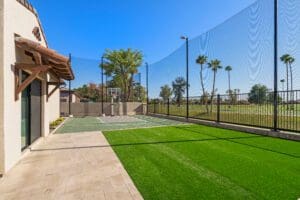 Luxury design-build backyard in Chandler, AZ, featuring a custom outdoor basketball court, professional artificial turf landscaping, and a modern home exterior.