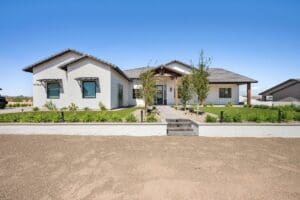 Modern Custom home by Easton Gray Development in San Tan Valley, featuring expert desert landscaping, a paved driveway, and elegant white architecture in Arizona