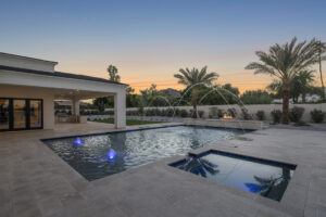 Luxury custom pool and spa with evening lighting and desert landscape