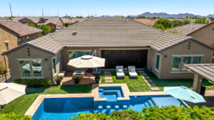 Integrated design-build custom home in Queen Creek, AZ, featuring a modern geometric swimming pool, raised spa, and professional desert landscaping.