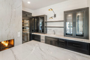 Custom home bar design in Paradise Valley, AZ, with white marble countertops, integrated wine storage, and contemporary accent lighting.