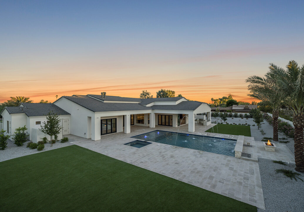 Luxury custom boutique resort style backyard with custom landscaping, geometric pool with spa and water features in Paradise Valley, Arizona